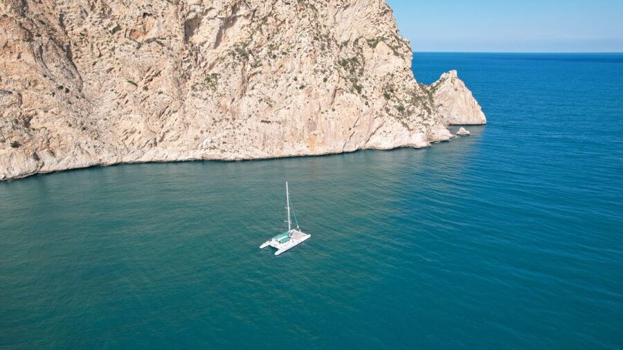 Calpe: Catamaran Tour with Optional Swim Stop - Passing beneath the shadow of Peñon de Ifach