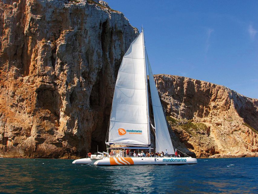 Dénia & Jávea: Portixol Sailing Catamaran Excursion with BBQ - Leaving port and following the Dénia coast