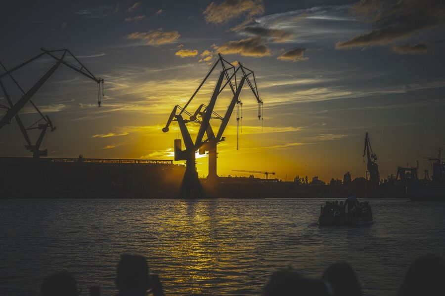 Gdańsk: Sunset Cruise on a Historic Polish Boat - Watching the sun set beside shipyard cranes