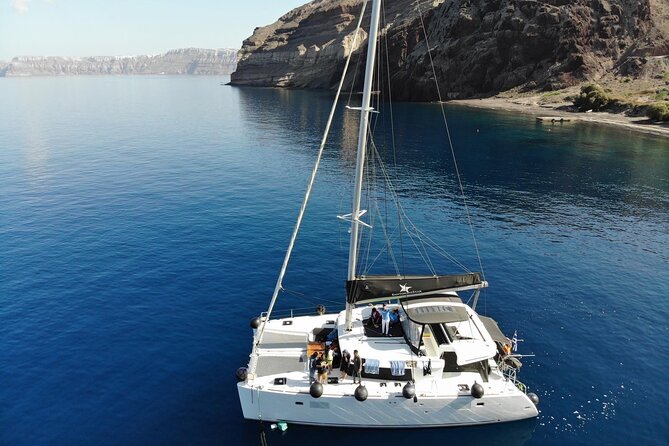 Half-Day Exclusive Catamaran Cruise in Santorini with Meal and Open Bar - White Beach, Mesa Pigadia, and the old lighthouse
